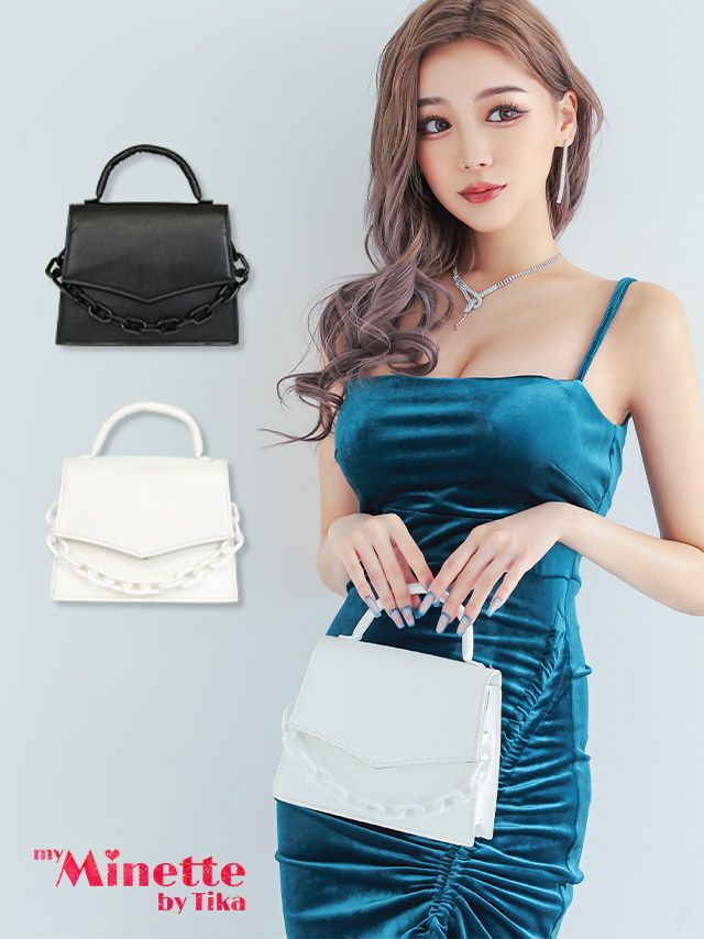 暗めのドレスによく映える真っ白なチェーンデザインがアクセントのハンドバッグ